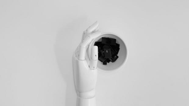 Main de robot tenant des touches de clavier